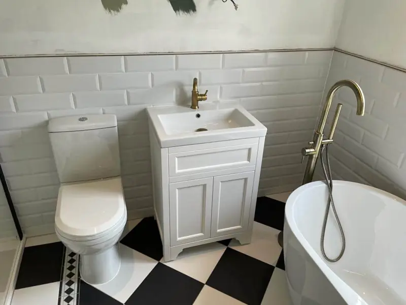 White vanity, freestanding bath and chequered floor