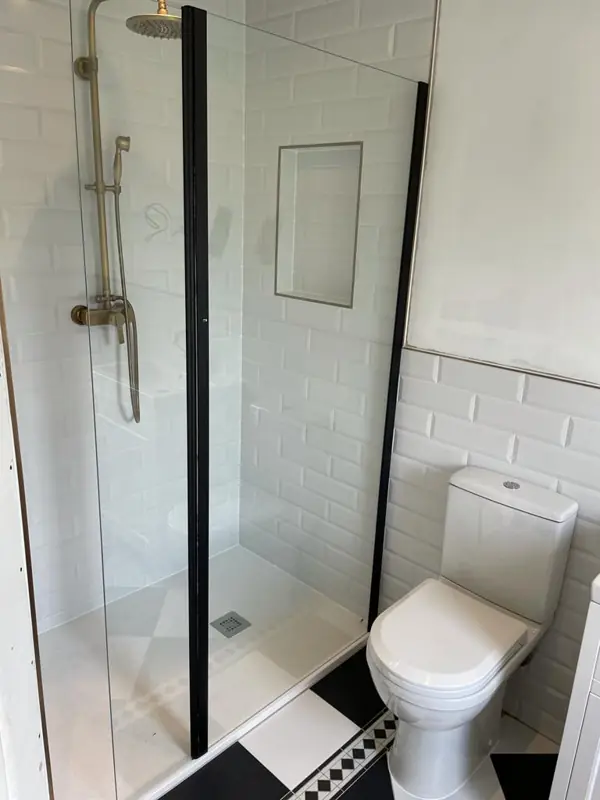 Shower with black framed screen and metro tiles