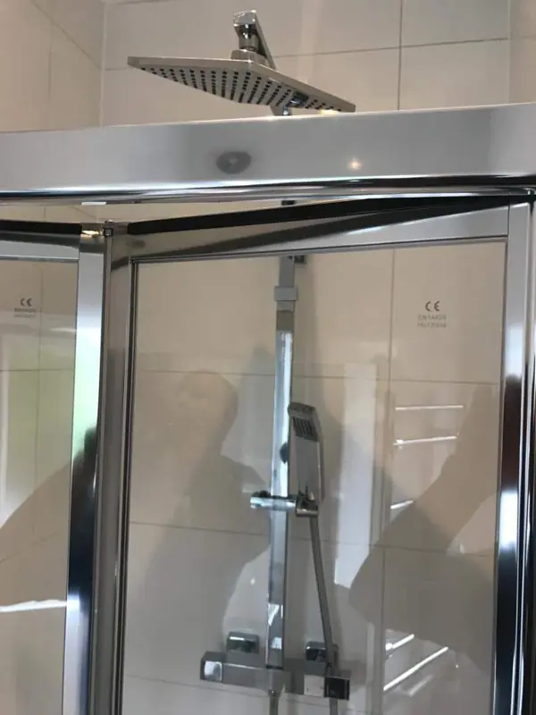 Shower enclosure with rainfall head and thermostatic valve