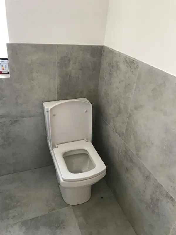 Close coupled toilet on grey tiles