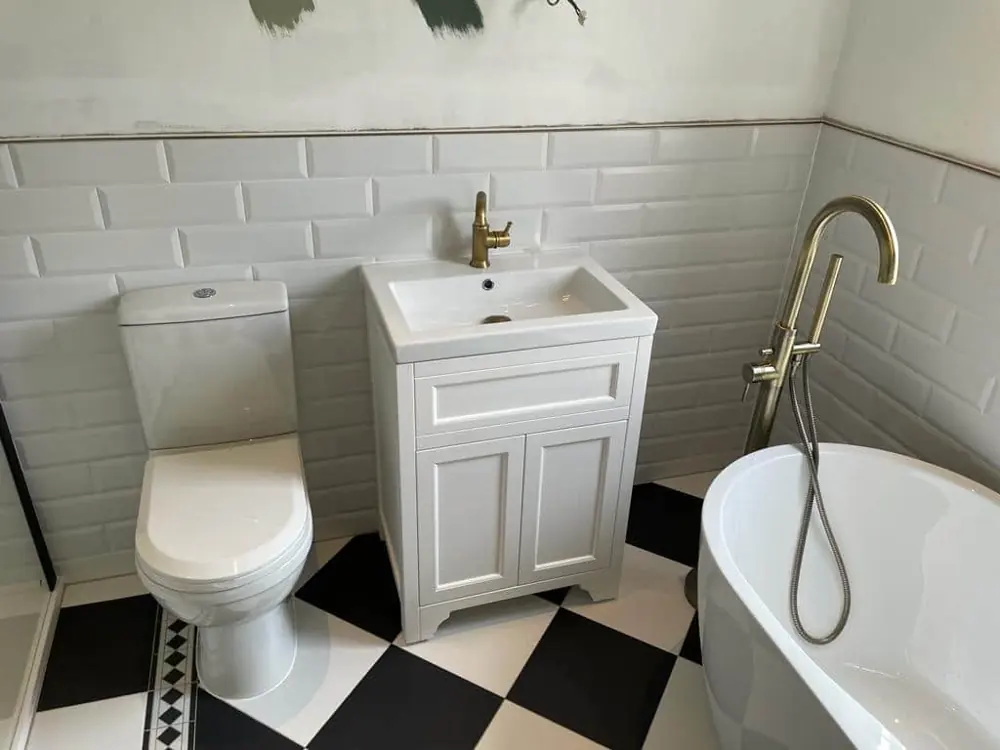 White vanity unit, freestanding bath and chequered floor