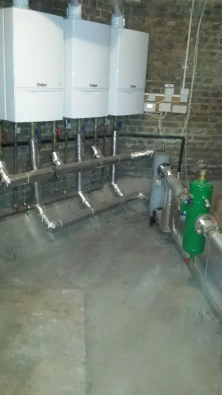 Plant room pipework below a bank of boilers