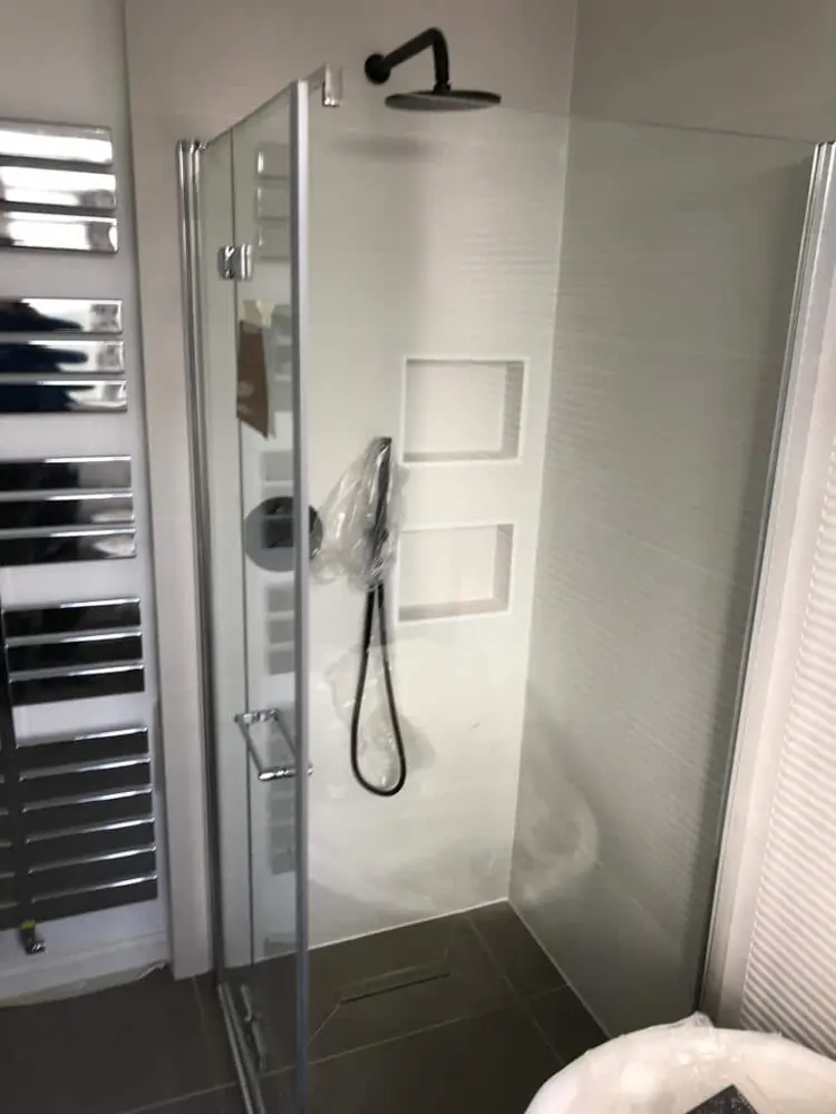 Walk-in shower with rainfall head and recessed shelf