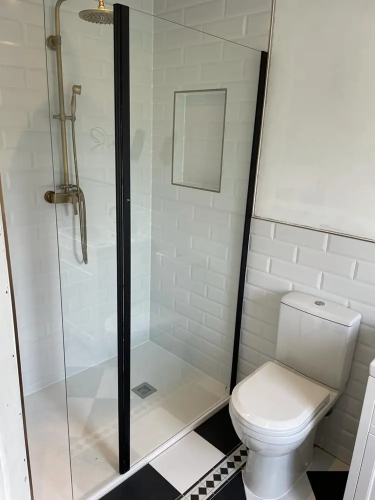 Shower with black framed screen and metro tiles