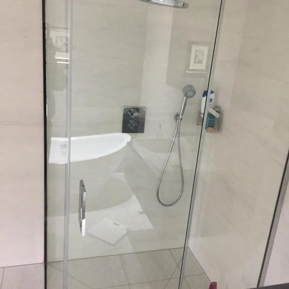 Frameless glass shower with handset